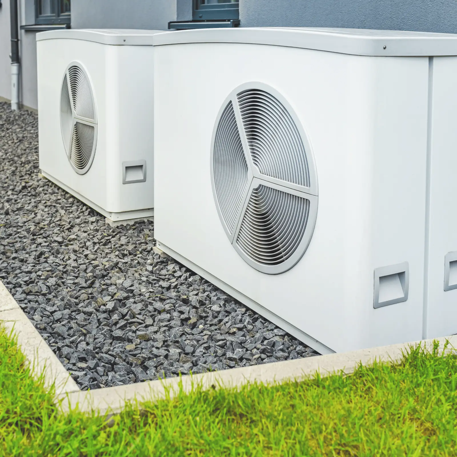 Outdoor residential air conditioning condenser units installed beside home